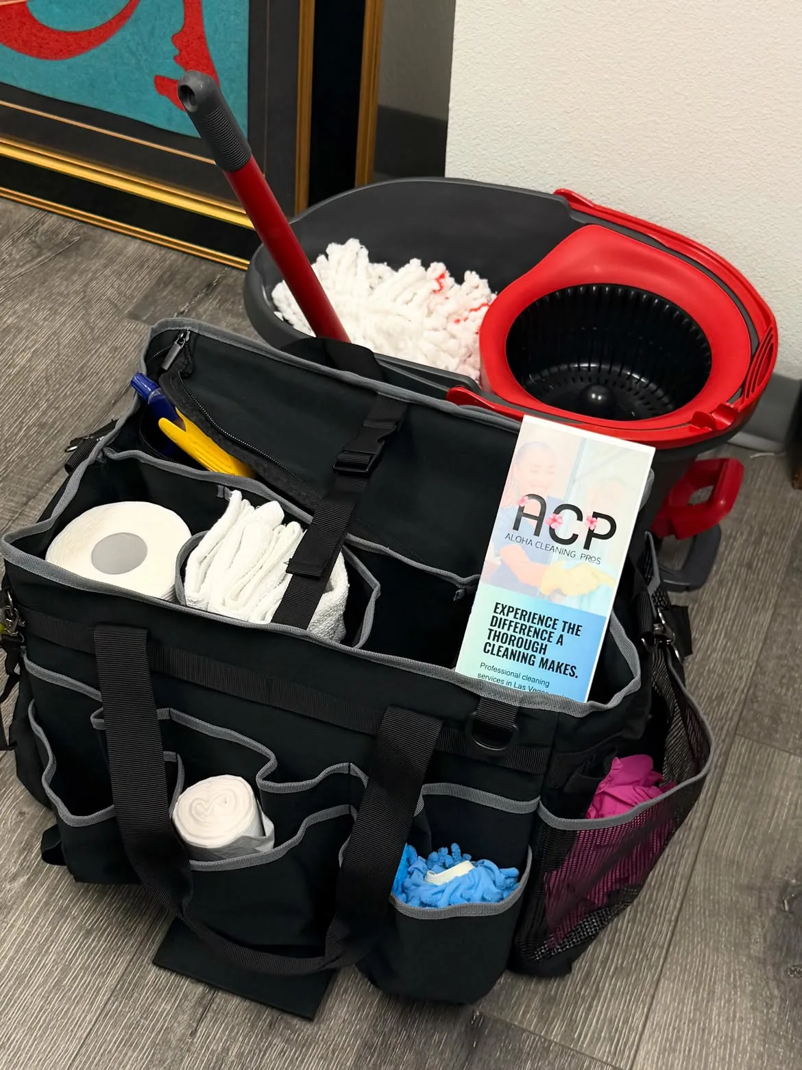 Black cleaning supply caddy filled with tools, cloths, and supplies for house cleaning service.